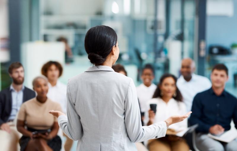Female presenting in front of group meeting