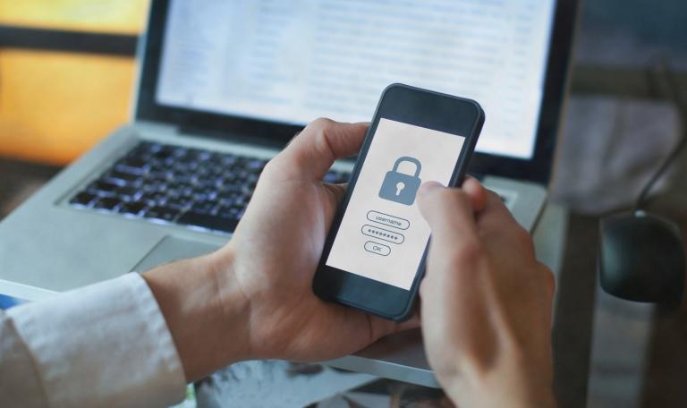 Security breach hand holding mobile with lock screen
