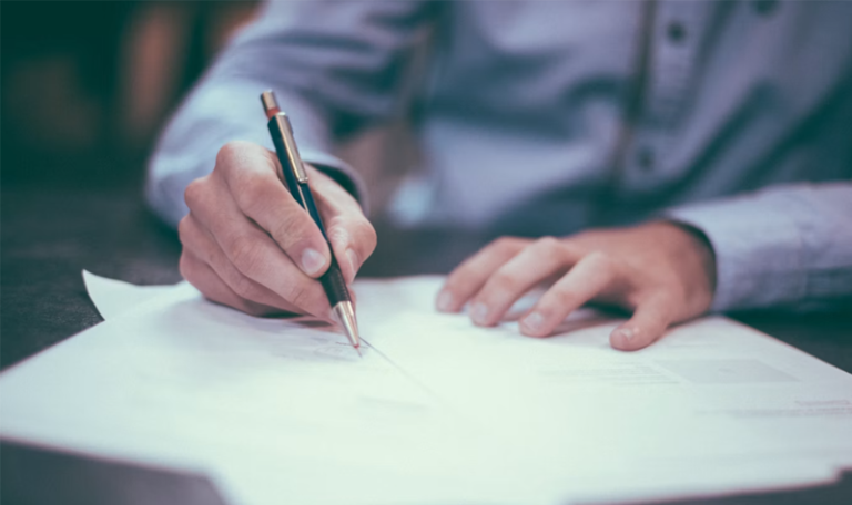 Man's hands signing document