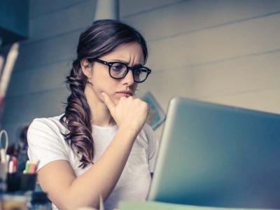 Confused looking woman looking  at a laptop