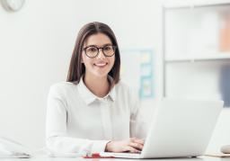 Female sitting at desk typing on a laptop computer