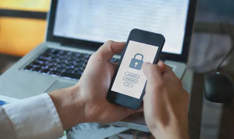 Security lock appearing on mobile phone screen in persons hand