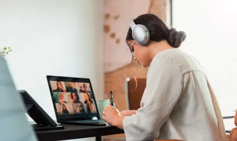 Student working remotely with laptop and headphones